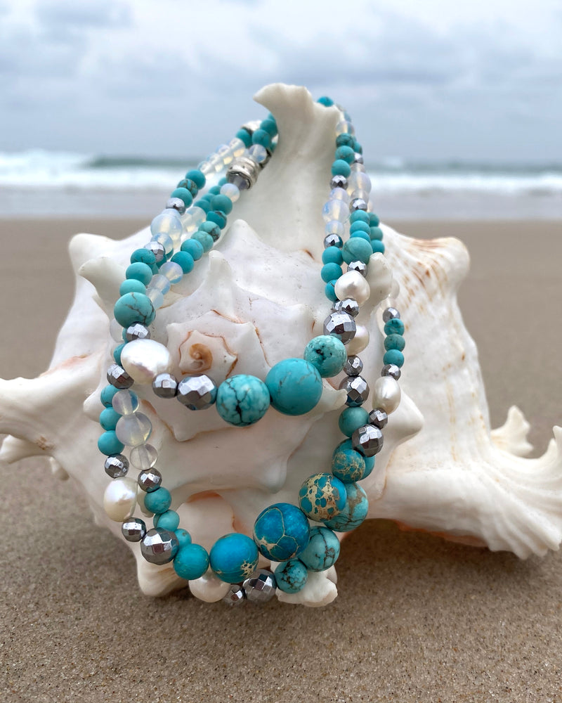 Intentional jewellery hand made in Byron Bay. Boho style natural crystal anklet featuring blue howlite, sea-sediment jasper, hematite, freshwater pearls and Opalite Moonstone beads strung on durable jewellers elastic.