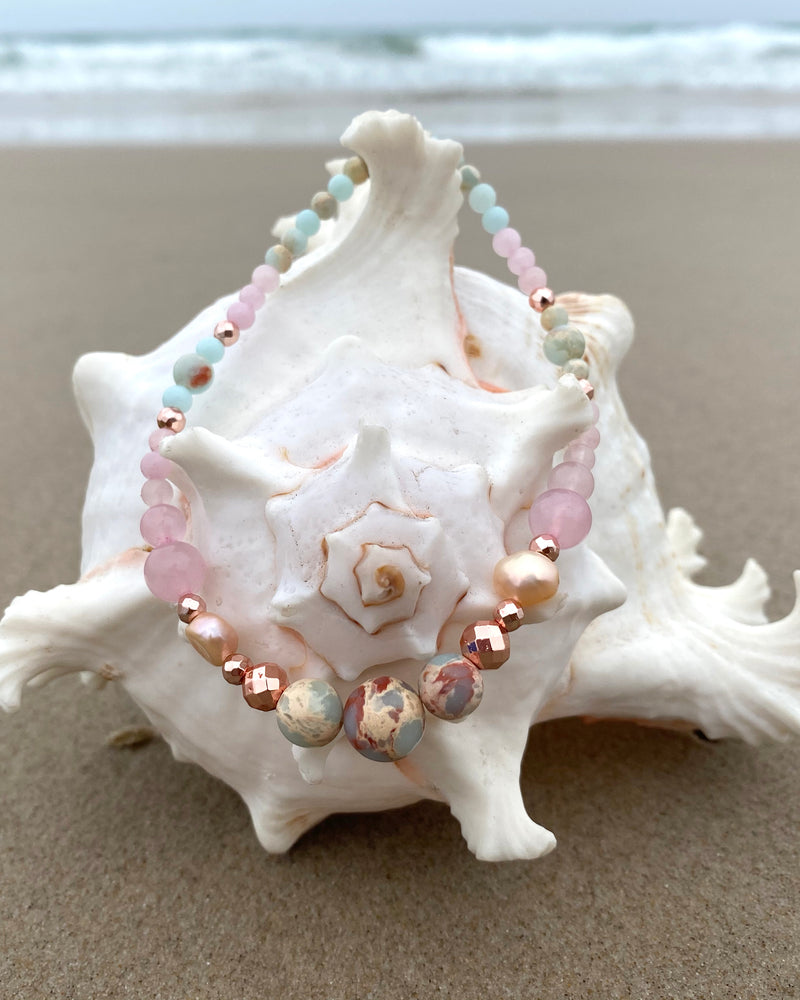 Intentional jewellery hand made in Byron Bay. Boho style natural crystal anklet featuring rose quartz, blue howlite, sea-sediment jasper, hematite, freshwater pearls and white alabaster beads strung on durable jewellers elastic.