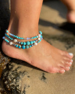 Intentional jewellery hand made in Byron Bay. Boho style natural crystal anklet featuring blue howlite, sea-sediment jasper, hematite, freshwater pearls and Opalite Moonstone beads strung on durable jewellers elastic.