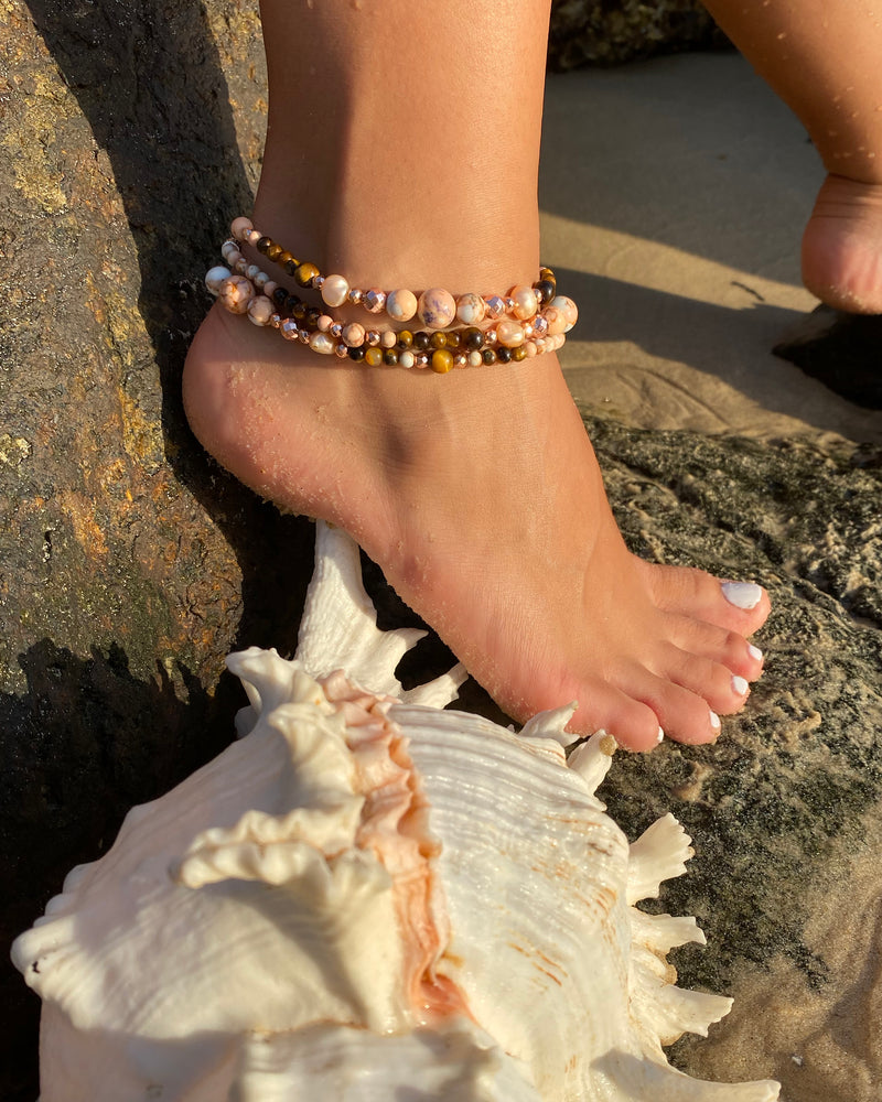 Intentional jewellery hand made in Byron Bay. Boho style natural crystal anklet featuring tiger eye, pink ocean jasper, hematite and freshwater pearl beads strung on durable jewellers elastic.