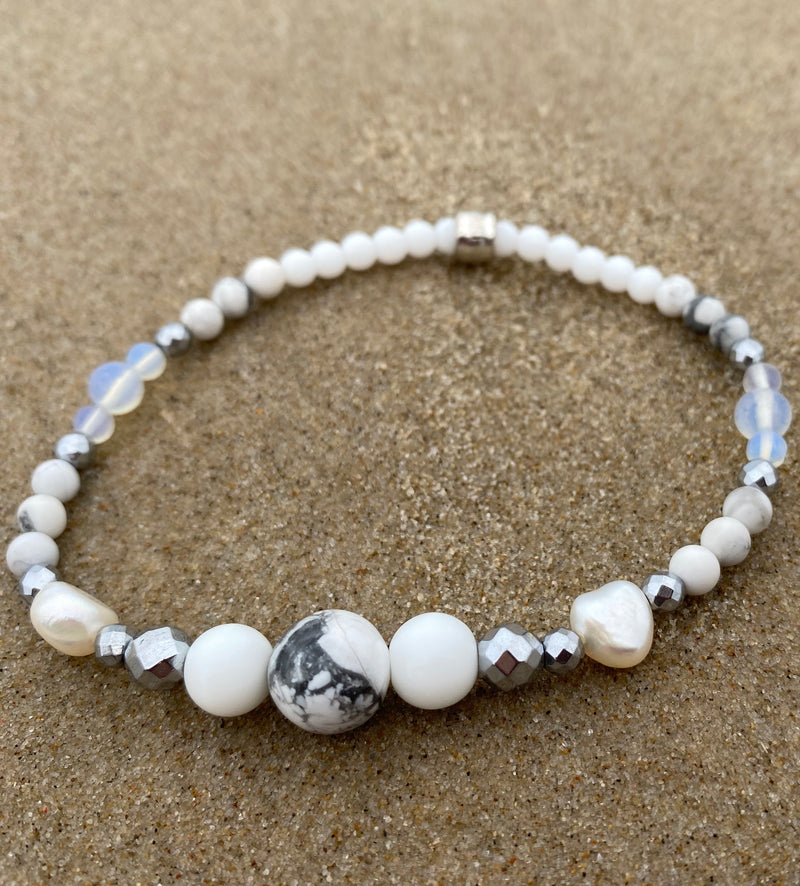 Intentional jewellery hand made in Byron Bay. Boho style natural crystal anklet featuring white alabaster, howlite, hematite, freshwater pearls and Opalite Moonstone beads strung on durable jewellers elastic.